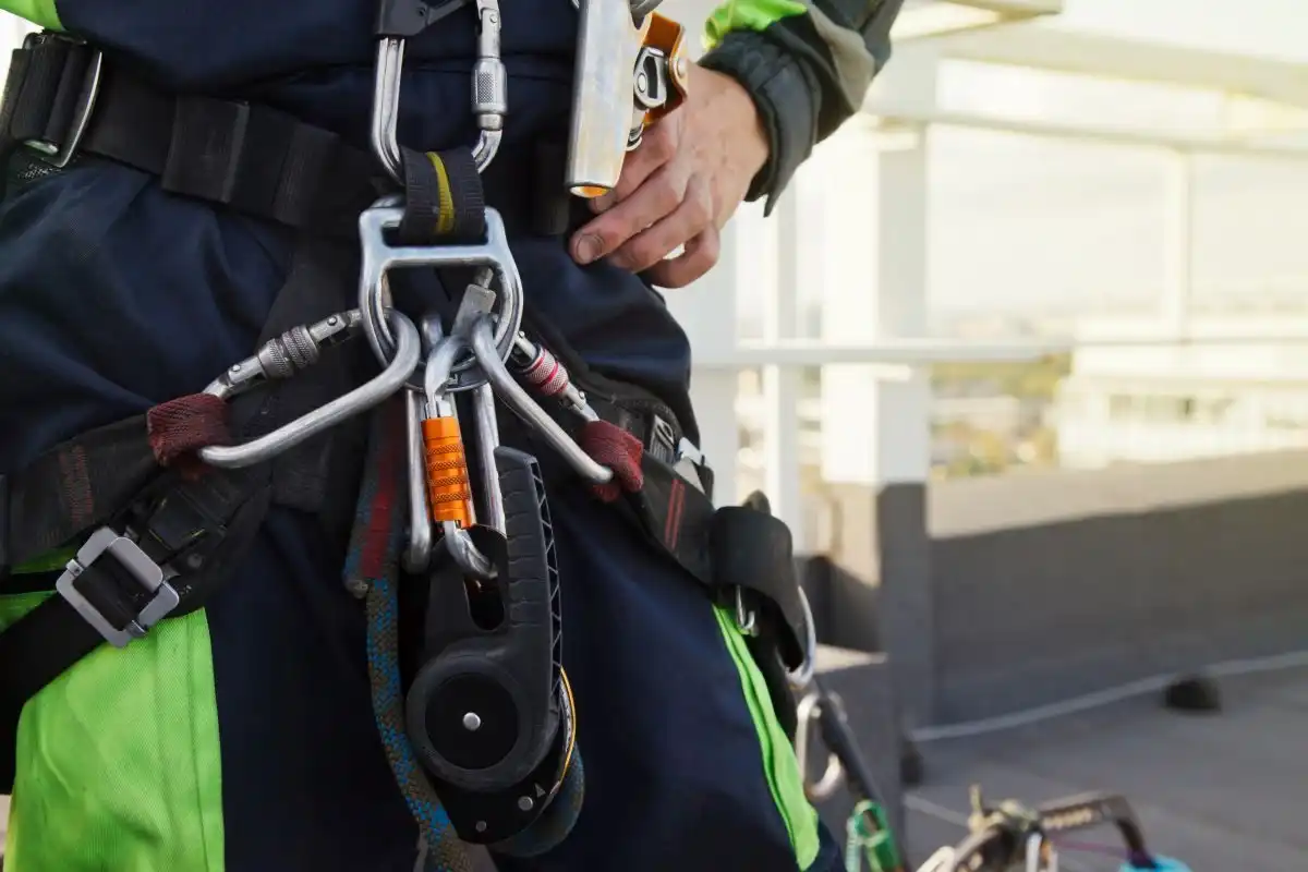 Harness with descender and karabiners on a plant roof