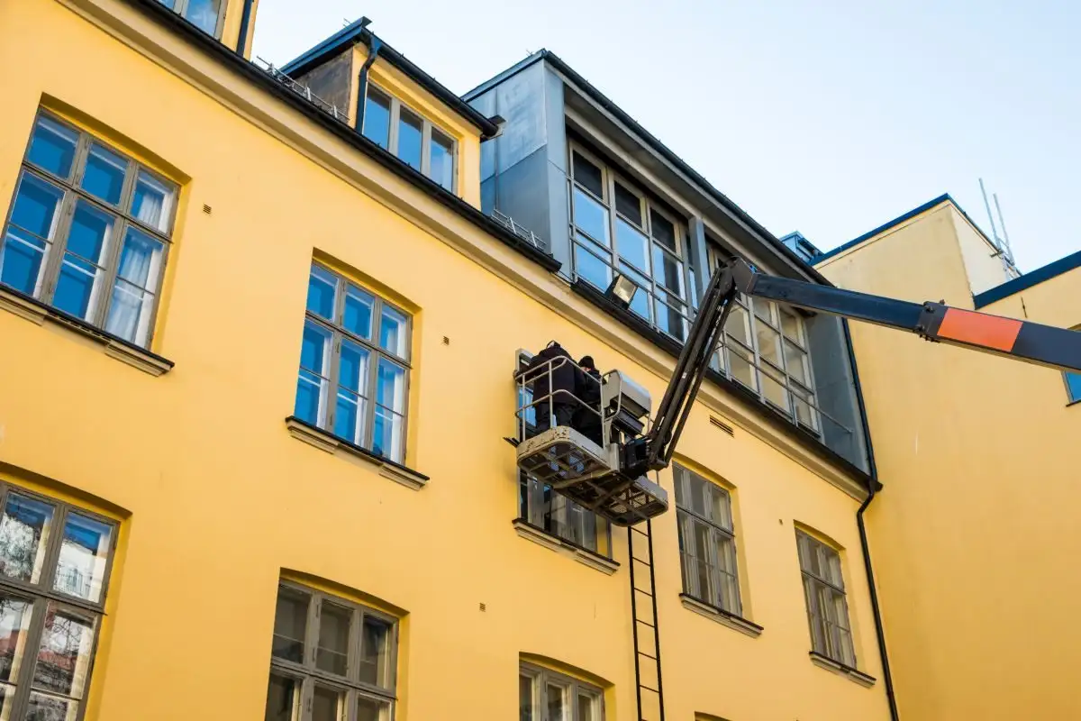 Articulated boom lift next to a building façade